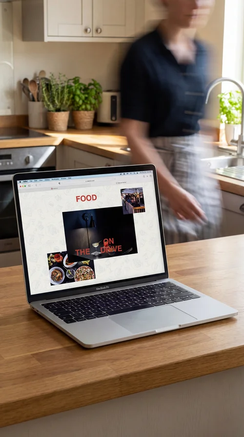 Open laptop on a wooden kitchen table displaying the Bar Corso website, a sunlit kitchen in the background.